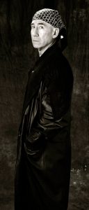 Standing, profile, long leather coat.